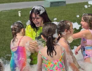 Campers are having a blast playing in the foam at the YMCA summer day camp