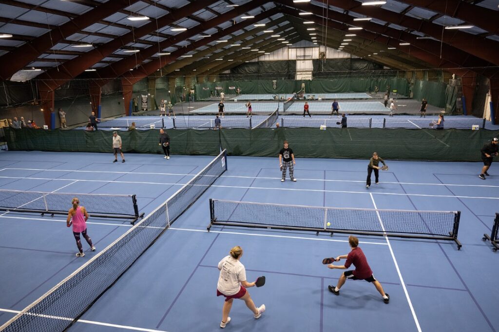 Players enjoy pickleball on the renovated indoor courts at Sinking Spring YMCA, with multiple games taking place throughout the facility.
